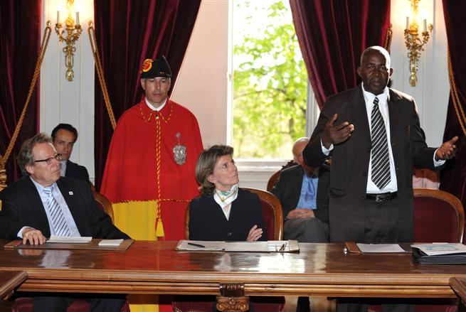 Pierre Claver Mbonimpa évoque son action pour la protection des détenus au Burundi. Assis à la table : Isabel Rochat, conseillère d'Etat, et Roger Durand président de la Fondation Prix Henry Dunant. Hôtel de ville de Genève, salle de l'Alabama, mardi 5 avril : remise du Prix Henry Dunant Terrain 2011.